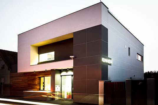 The CANEX office building at dusk, its sign lit on the facade